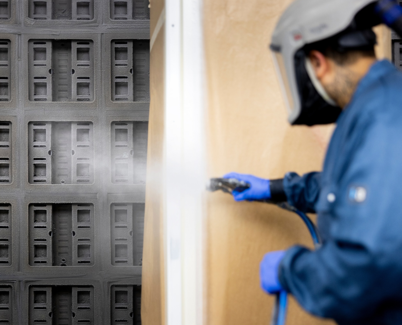 Ein Mitarbeiter in blauer Arbeitskleidung überprüft einen edrizzi® Farbnebelabscheider in einer industriellen Filteranlage.